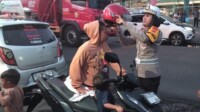 Kasat Lantas Polres Bitung, AKP Dwi Dea Angraini, S.I.K., M.H., saat memberikan Helm ke pengendara motor yang tidak memakai Helm. Selasa, 18/11/2025. (Foto.Humas Polres)