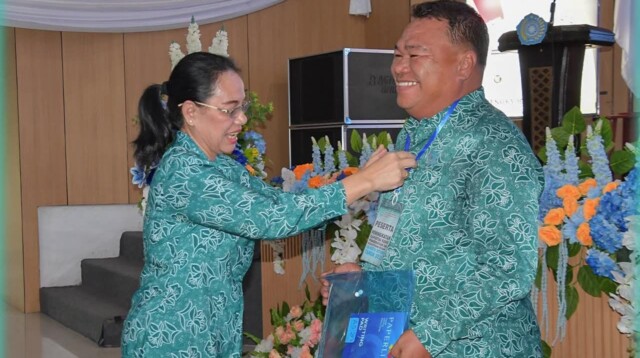 Ketua TP-PKK Kota Bitung Ny. Ellen Honandar Sondakh SE saat memasang tanda peserta kepada Kepada Ketua TP-PKK Kecamatan Maesa Bpk Harisanto Passa