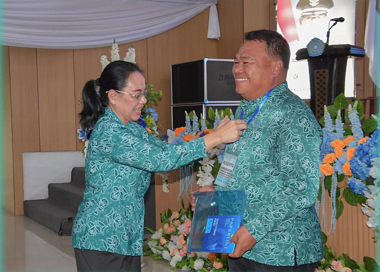 Ketua TP-PKK Kota Bitung Ny. Ellen Honandar Sondakh SE saat memasang tanda peserta kepada Kepada Ketua TP-PKK Kecamatan Maesa Bpk Harisanto Passa