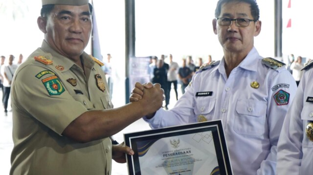 Gubernur Sulawesi Utara Mayjen TNI (Purn) Yulius Selvanus SE saat menyerahkan Penghargaan K3 Kepada Wali Kota Bitung Hengky Honandar SE. Rabu (25/02/2026).